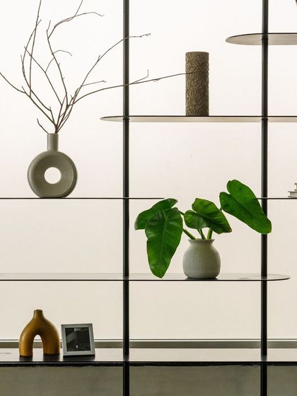 A close-up of the decorative shelving, where simple, sculptural objects are carefully arranged to create a point of visual interest against the diffused light.