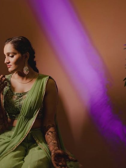 An artistic portrait of the bride in her green Mehendi outfit, with a streak of purple light adding a creative and modern touch.