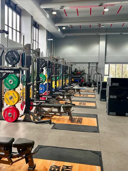 Our high-performance center is equipped with world-class Hammer Strength gear. This view of our weightlifting platforms and power racks shows the professional environment where our members train. We provide the best equipment to support your strength and fitness goals.
