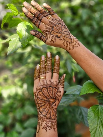 A view of both hands, showing the custom peacock design. This is a great option for someone who wants a traditional motif with a modern, less-is-more approach.