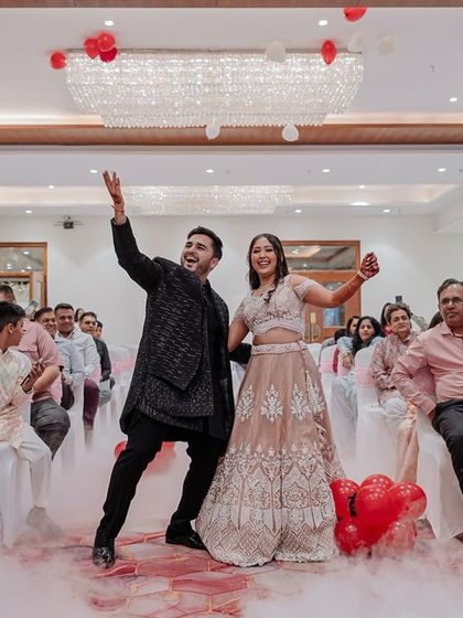 The couple's energetic dance entrance at their Sangeet, surrounded by smoke and cheered on by their guests.