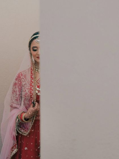 A playful, hide-and-seek portrait of the bride peeking out from behind a wall. This image is creative and artistic, showing a different side of bridal photography.