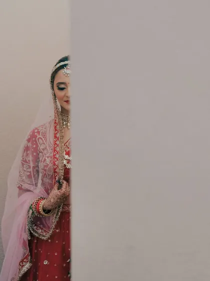 A playful, hide-and-seek portrait of the bride peeking out from behind a wall. This image is creative and artistic, showing a different side of bridal photography.
