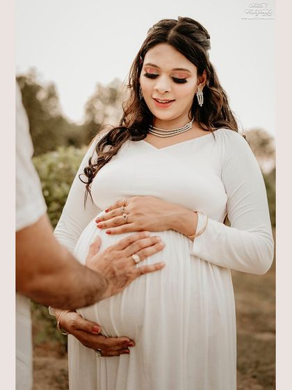 A close-up shot focusing on the hands of both parents cradling the baby bump. It’s a simple yet incredibly powerful image symbolizing protection, love, and unity.