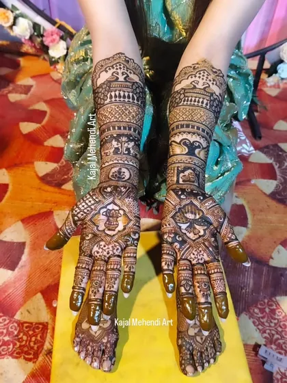 A top-down view of a stunning bridal mehndi, showing the full design from fingertips to forearms. This piece includes traditional symbols like Ganesha and peacocks for blessings and beauty.
