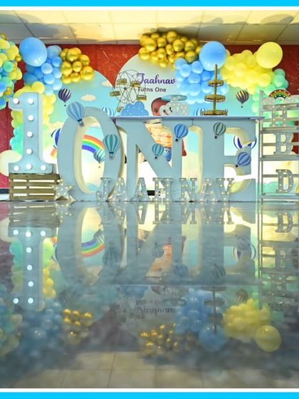 A reflective floor shot of a hot air balloon-themed first birthday, creating a beautiful mirror image of the setup.