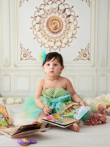 Study time. This little girl looks up from her book with a curious expression, a sweet moment from a classic studio session.