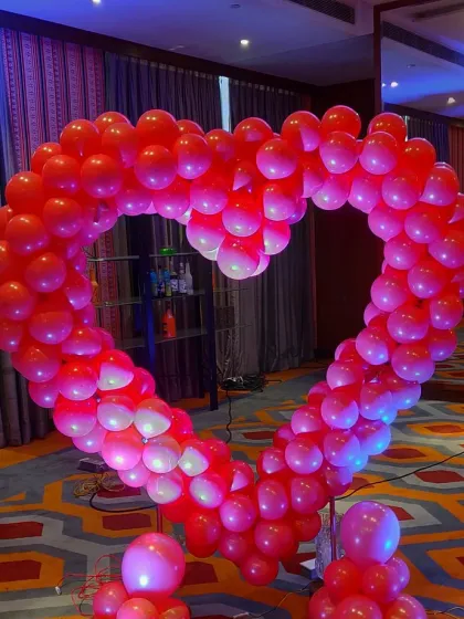 A large, freestanding heart-shaped arch made entirely of red balloons. This makes a bold and romantic statement for any anniversary or Valentine's Day celebration.
