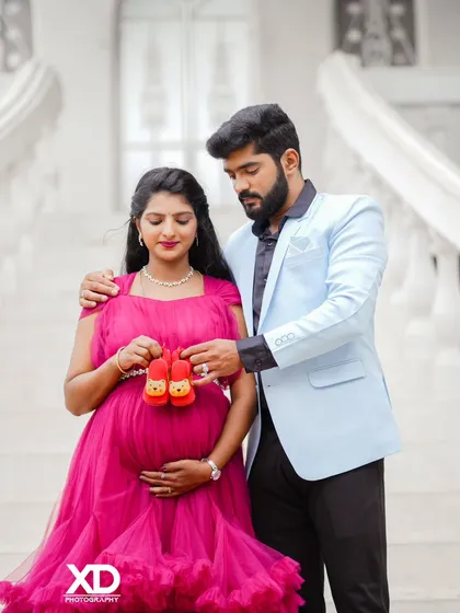A sweet photo of a couple holding tiny baby shoes together, symbolizing their shared excitement.