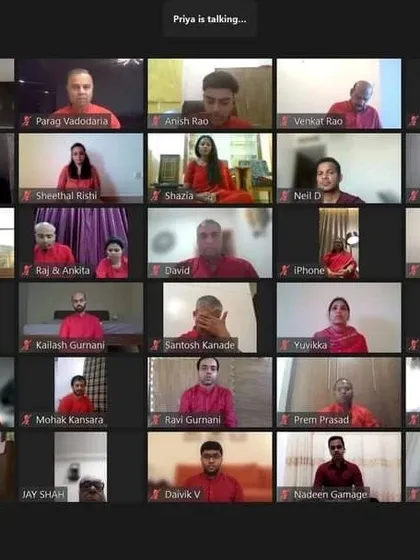 Participants in our online Prosperity workshop, all wearing red and listening intently. The color coordination enhances the collective energy, even in a virtual setting.