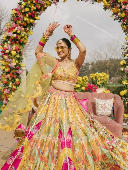 A Haldi ceremony is all about joy and color. For this bride, we chose a vibrant, multi-hued lehenga that was as playful and full of life as the celebration itself, complete with fun sunglasses for a modern twist.