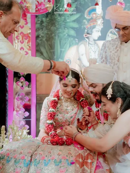 A candid moment of blessings during the wedding ceremony. The gentle shower of petals from family members adds a layer of warmth and tradition to the celebration.