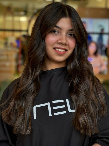 This frontal view shows how the balayage brightens up her overall look. The placement of the highlights around the face is key to this flattering effect.