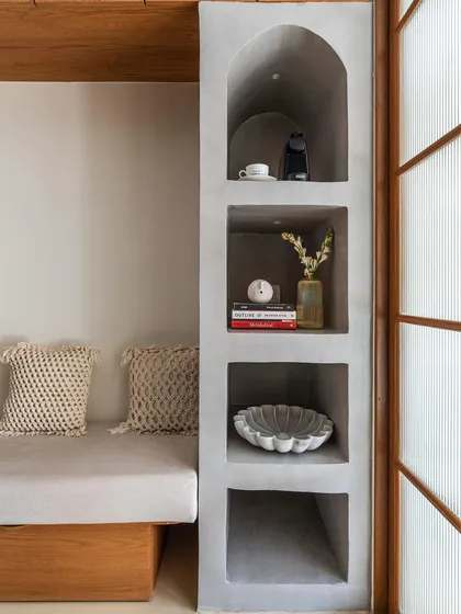 Texture and warmth are so important in making a space feel like home. Here, I used a smooth cement finish for the built-in shelving to contrast with the soft fabrics and natural wood, creating a calm and inviting reading nook.
