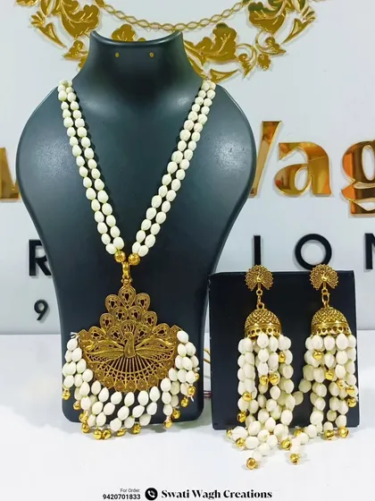 Another view of the unique golden and floral jewellery combination. The large peacock-inspired pendant is a true statement piece.