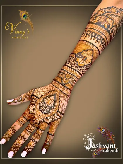 A regal back-of-hand design with a central lotus teardrop motif. The forearm is decorated with bands of floral and elephant patterns.