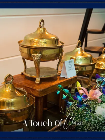 A touch of class. This close-up highlights the ornate details on one of our brass chafing dishes, part of our collection of premium serveware that elevates any buffet.