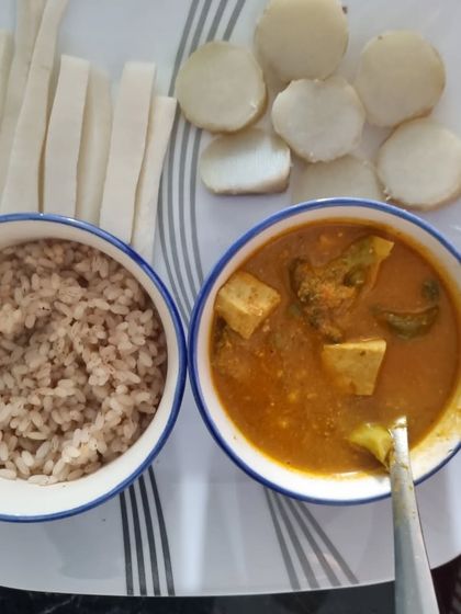 This meal is all about whole foods. It includes a bowl of brown rice, a simple tofu curry, and a side of sliced taro root and radish. This combination provides complex carbs, plant-based protein, and plenty of fiber to keep you full and energized.