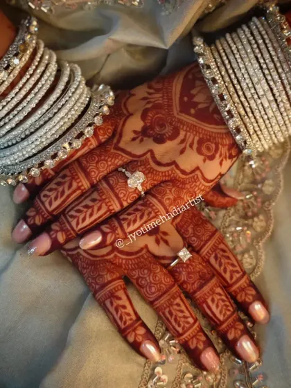 The final result is everything. This photo shows the deep, reddish-brown stain my organic henna achieves after setting. Paired with bridal bangles, the intricate patterns truly stand out, ensuring your hands look stunning on your big day.