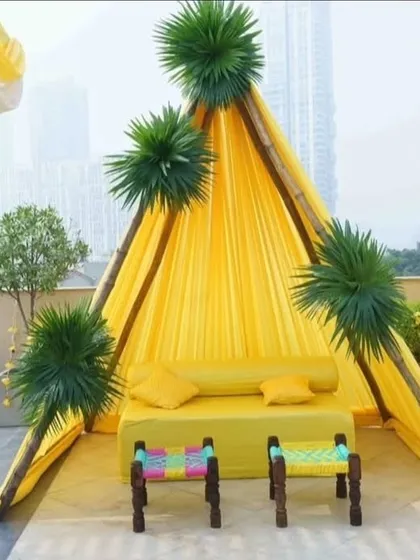 I created this cozy teepee-style seating area as a photo corner for the Haldi event. The bright yellow fabric and simple stools provide a fun and stylish spot for guests to take pictures.
