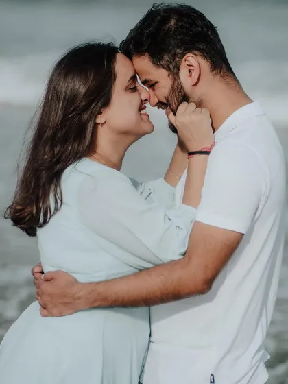 A playful and affectionate moment, capturing the fun and loving nature of the couple's relationship by the sea.