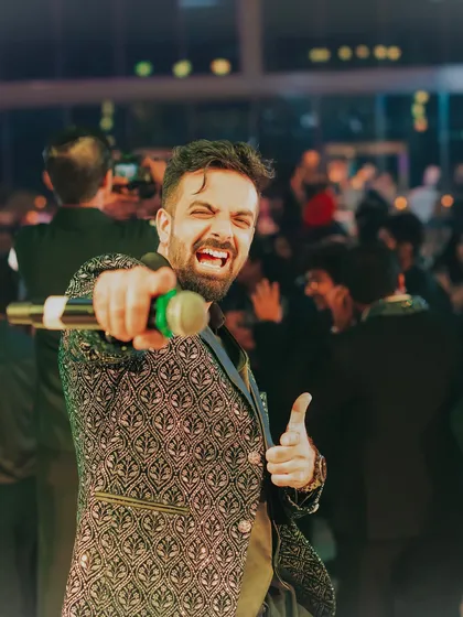 Pointing to a guest in the crowd, making sure everyone feels included in the celebration. Interactive hosting is key to a memorable party.