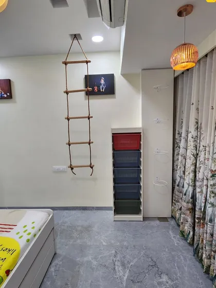 This kids' room includes fun elements like a rope ladder, encouraging play and activity.