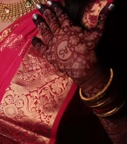 A beautiful, moody shot of a mature stain with the couple's initials. The deep color looks so rich against the red saree.