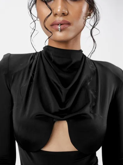 A detailed close-up of the edgy makeup, featuring a smokey eye and a nude lip. The wet-look tendrils of the hair add texture and frame the face beautifully.