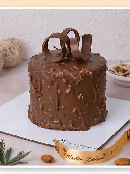 This Dutch Truffle style cake is coated in a rich chocolate and almond mixture, offering a delightful crunch with every bite. The chocolate curls on top add a touch of elegance.