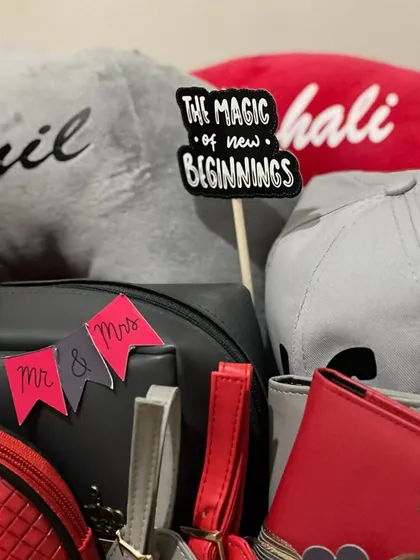 "The Magic of New Beginnings". This close-up shows the personalized caps and pouches from a couple's hamper, a perfect gift to celebrate their new life together.