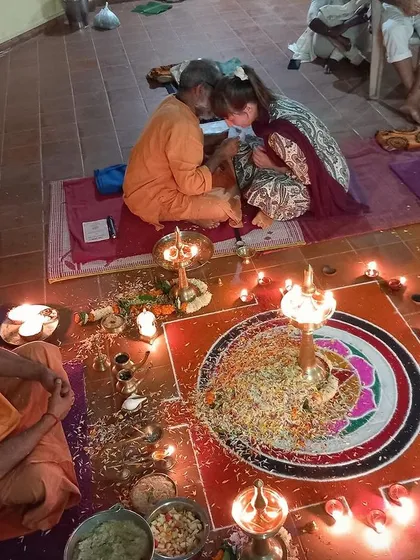 A student receives blessings during a puja ceremony. These traditional Vedic rituals are a profound opportunity to connect with the divine and experience the devotional aspects of yoga.