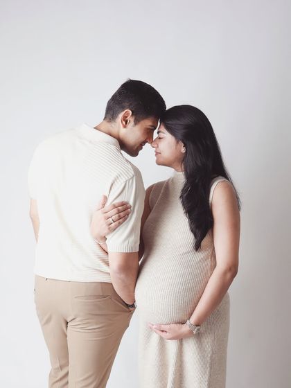 An intimate forehead to forehead pose against a clean background. This minimalist approach strips away all distractions, focusing solely on the deep connection between the parents to be.