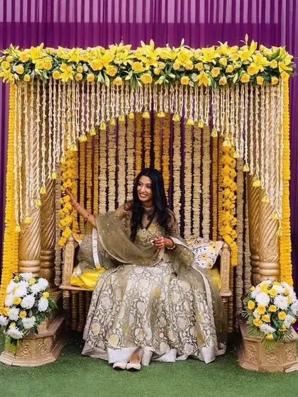 I design classic decor for traditional ceremonies like this Haldi function. The setup is built around a beautiful seating swing, decorated with traditional yellow marigold and white flower garlands.