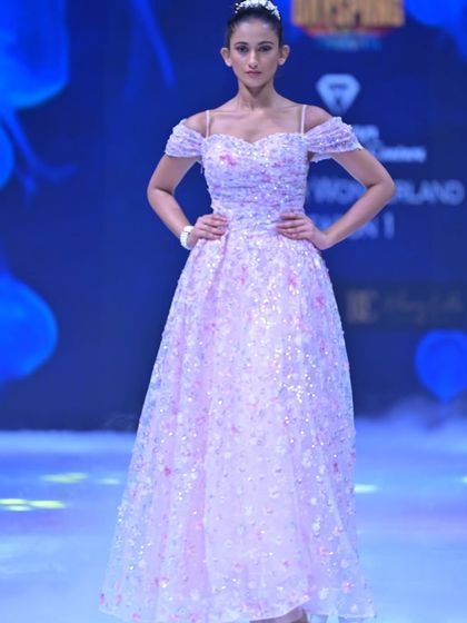 This off-shoulder A-line gown is covered in shimmering floral sequins, creating a look that is both romantic and glamorous. The movement of the fabric catches the light beautifully.