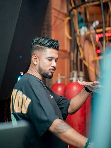 In the zone at a carnival-themed party. The industrial background with red gas canisters adds a unique, edgy vibe to the event.