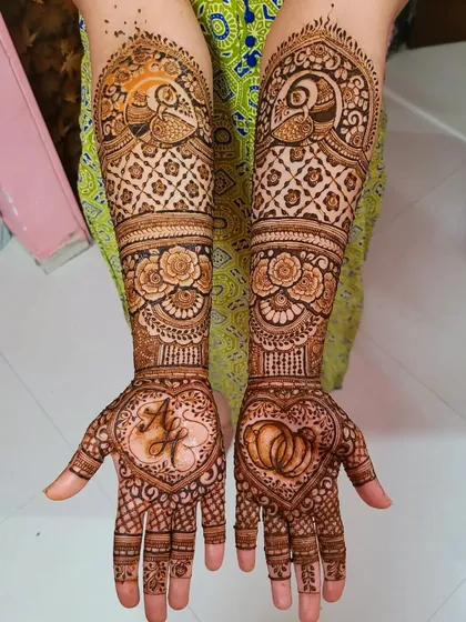 A lovely engagement henna design with the couple's initials inside a heart on one palm, and interlocking rings on the other. It's a sweet and symbolic way to celebrate.