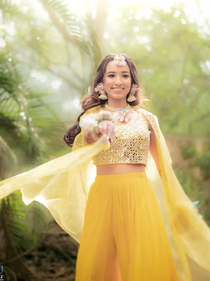 A joyful shot of the bride, with her yellow dupatta flowing. Our floral accessories are designed to be part of these picture-perfect moments.