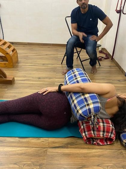 A student in a supported side-lying Savasana. This variation is very comforting and is often used in therapeutic and prenatal yoga sequences.