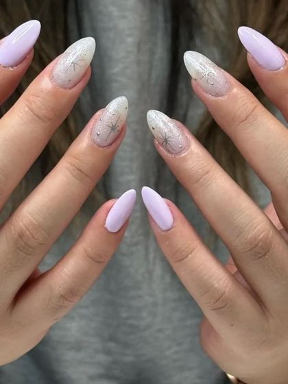 A beautiful set with a mix of solid lavender and accent nails with a delicate, web-like design and glitter.