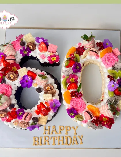 This "60" number cake shows a different style of celebration cake. Instead of a traditional tiered design, I use a tart base and load it with a vibrant arrangement of fresh fruits like strawberries and dragon fruit, rich chocolates, macarons, and edible flowers, offering a fresh and beautiful alternative.