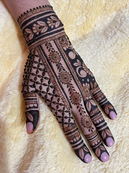 This full coverage design combines several techniques, including a floral vine strip, a dense crosshatch pattern, and a section with negative space and moon motifs.