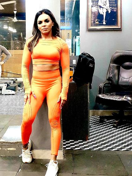 Posing in a bright orange set. I love bringing energy and color to my training sessions at M R Fitness Zone.