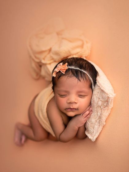 This little one is sleeping on a tiny lace pillow, looking absolutely angelic. The peach tones are so warm and lovely.