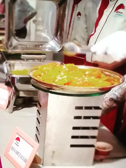 Our staff serving hot Kesari Jalebi at a live counter. The aroma and sight of freshly prepared sweets are always a crowd-pleaser.