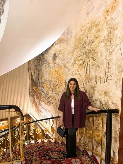 If there’s a gilded staircase, I’m taking a picture. This outfit features a Bhaane jacket I've had for a decade, showing how I mix old and new pieces to create classic, layered looks.