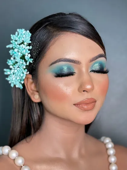 A detailed shot of a blue smokey glittery eye look. I teach the technique to build up the pigment for a rich color payoff and how to apply loose glitter precisely for a high impact, professional finish.
