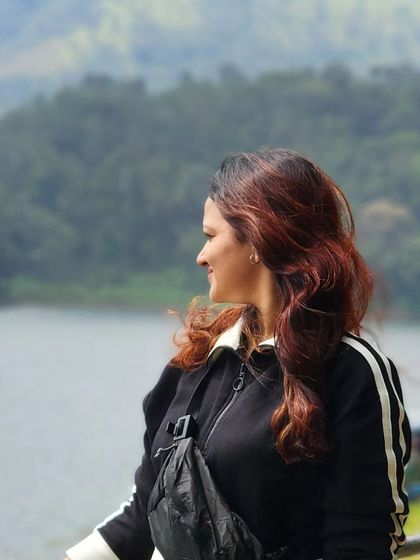 A candid moment of a traveler enjoying the view by the lake in Wayanad.
