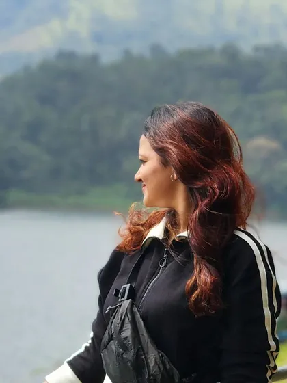 A candid moment of a traveler enjoying the view by the lake in Wayanad.
