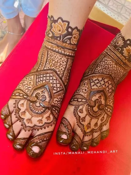 A top-down view of the bridal foot mehandi. This angle clearly shows the symmetry of the design on both feet, featuring peacock and floral elements.